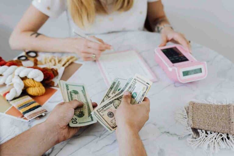 Person counting cash payment at small business counter – Invisible Fence Financing