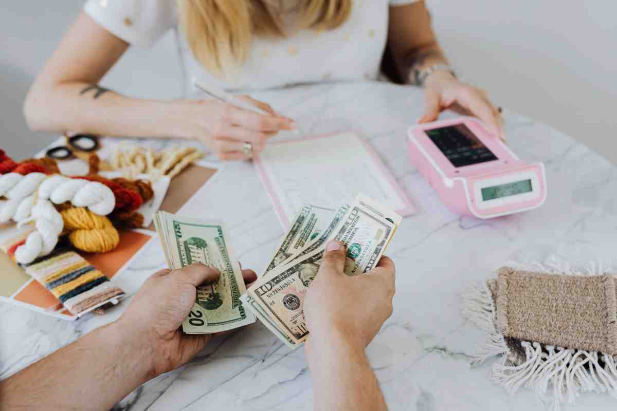 Person counting cash payment at small business counter – Invisible Fence Financing