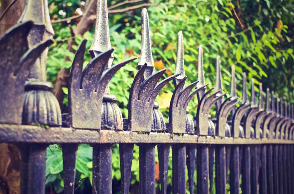 Ornamental steel picket fence with pointed tops, an example of the best fence for aggressive dogs needing a secure barrier